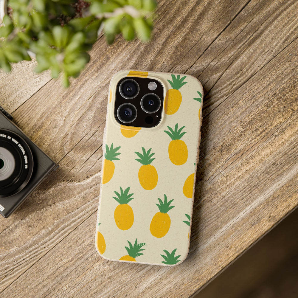 Eco-friendly iPhone case with playful pineapple design on a wooden table, offering durability for many iPhone and Samsung models.