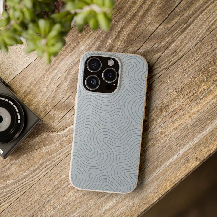 Eco-friendly abstract wave design phone case with vibrant colors on wooden table, compatible with many iPhone and Samsung models.