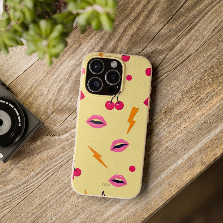 Eco-friendly Lip Service iPhone case with colorful lips and cherries design, showcasing vibrant personality on a wooden table.