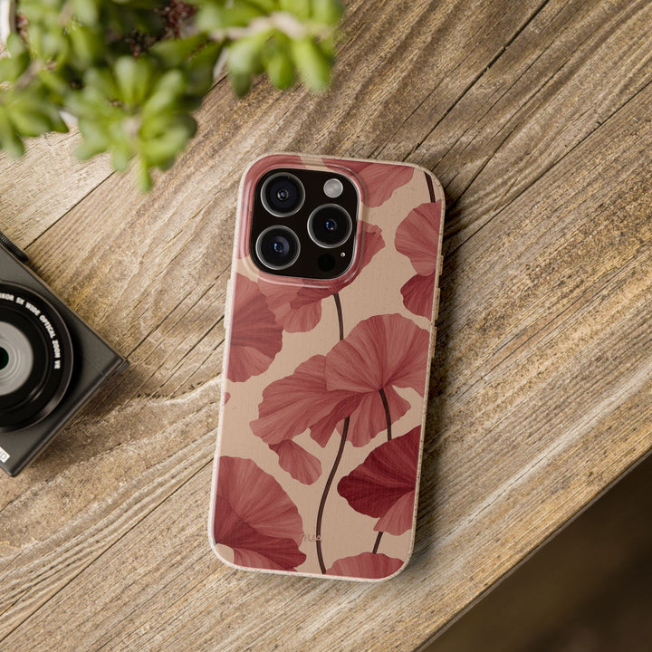 Luxury red floral design phone case made from eco-friendly materials for iPhone and Samsung models, resting on a wooden surface.