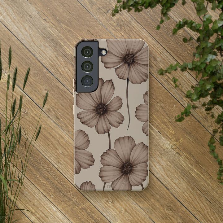 Eco-friendly beige floral Samsung phone case on wooden surface surrounded by greenery, elegant sustainable accessory.