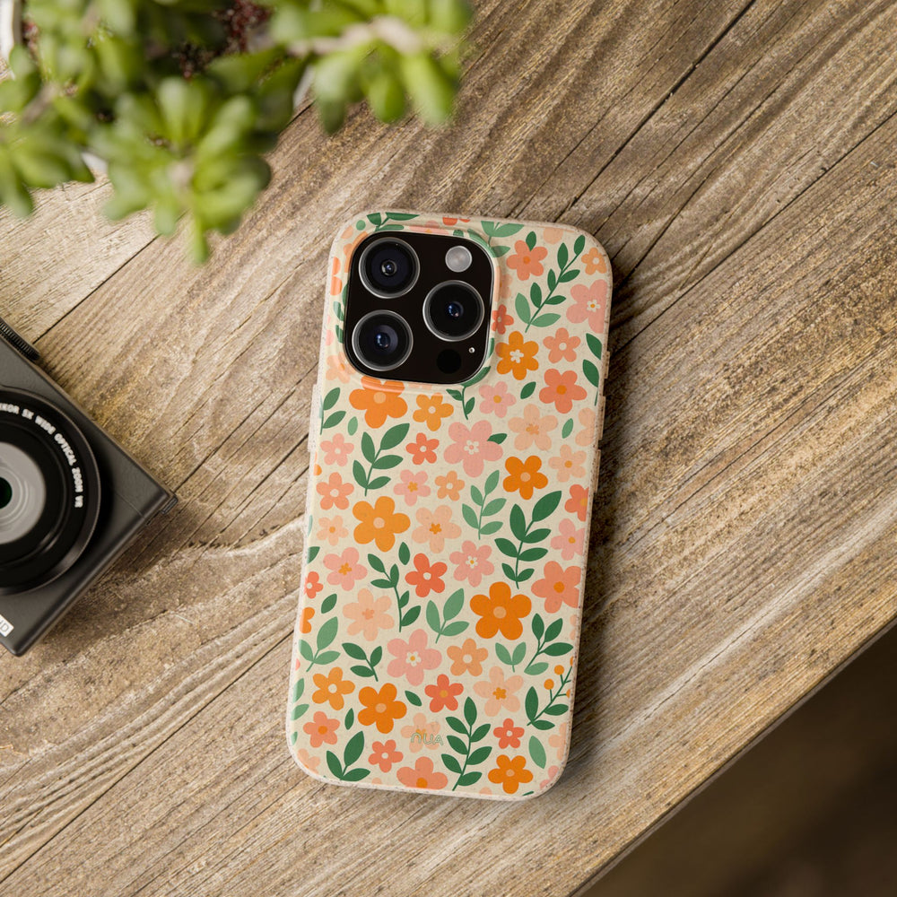 Eco-friendly floral biodegradable iPhone case on wood table, vibrant colors. Durable, fits many iPhone and Samsung models.