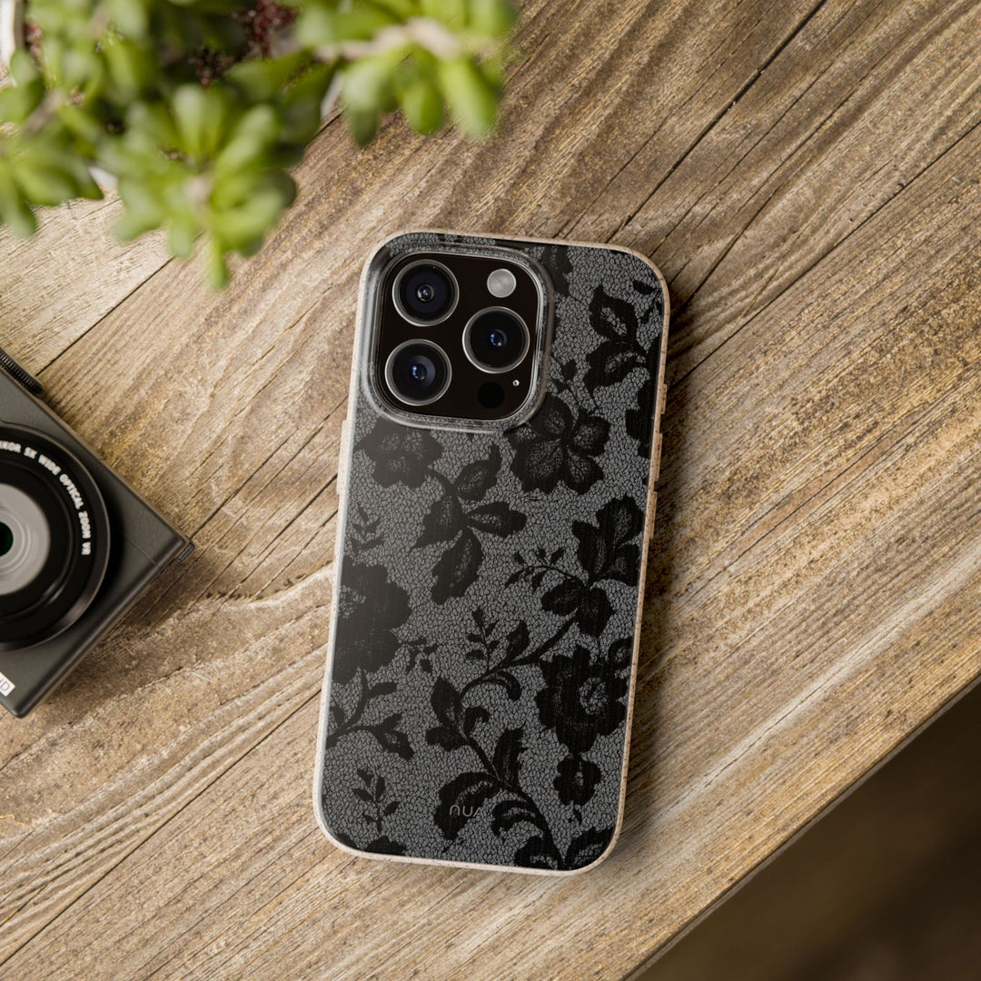 Eco-friendly floral black lace iPhone case on wooden table, compatible with many iPhone and Samsung models, durable and stylish.