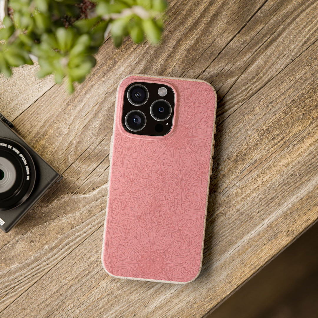 Rustic pink floral biodegradable phone case on wooden table, eco-friendly protection for iPhone and Samsung models.