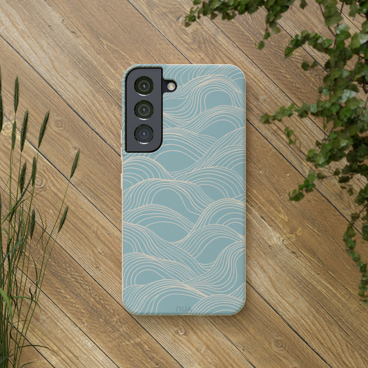 Eco-friendly blue wave Samsung phone case on wooden surface, designed for durability and style, fitting various models.