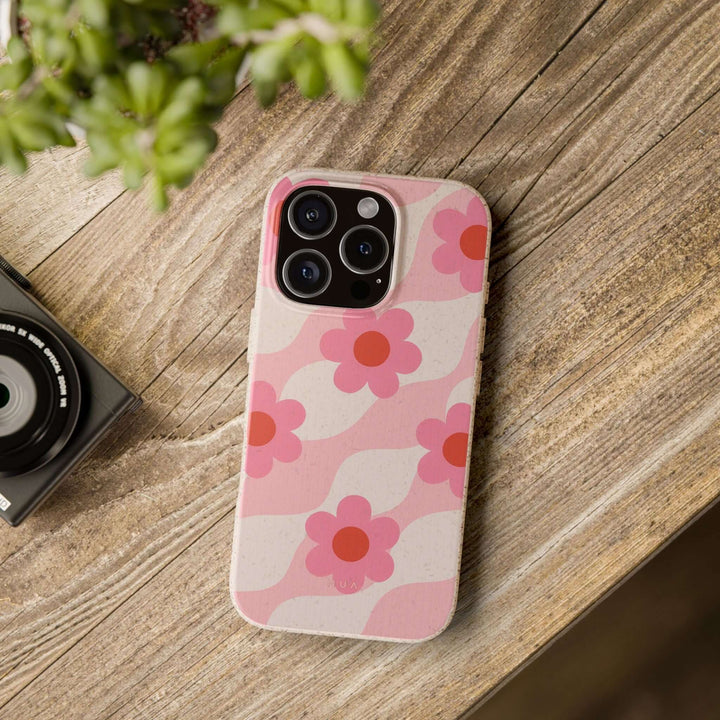 Eco-friendly Pink Retro Floral Vibe iPhone Case on wooden table, durable and stylish design, perfect for tech lovers seeking sustainability.